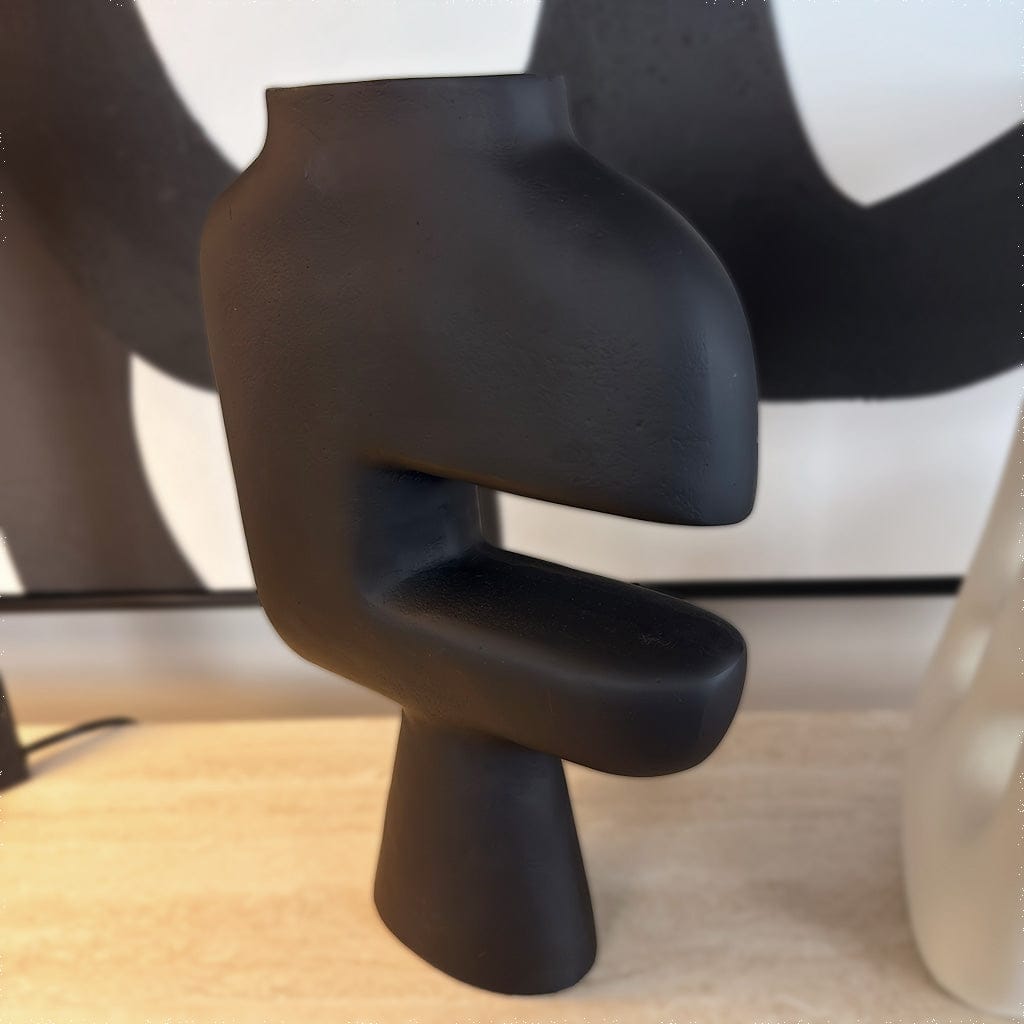 Black abstract sculpture on a neutral background