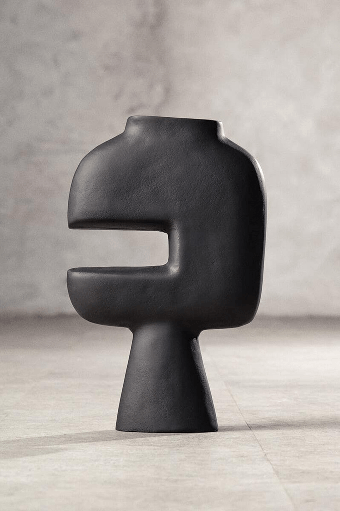 Modern black vase on a gray surface with a neutral background