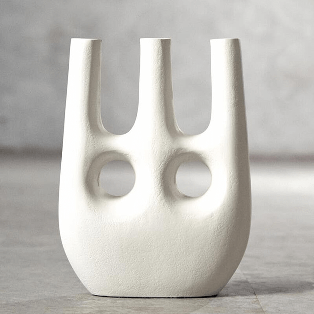 White abstract vase with two circular holes on a gray background