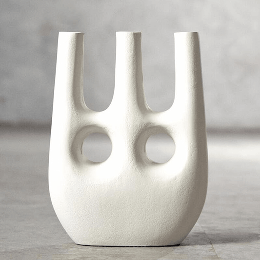 White abstract vase with two circular holes on a gray background