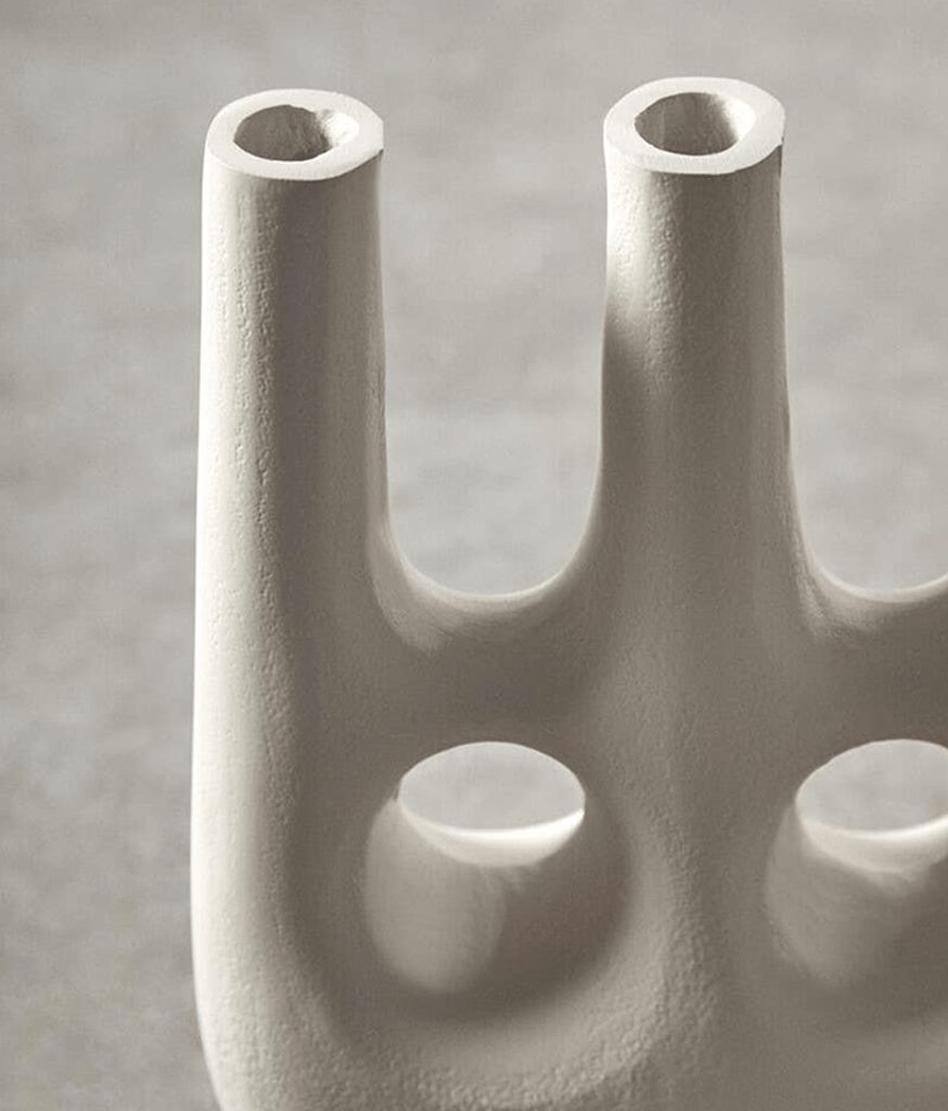 Abstract sculpture of interconnected cylindrical forms on a gray background
