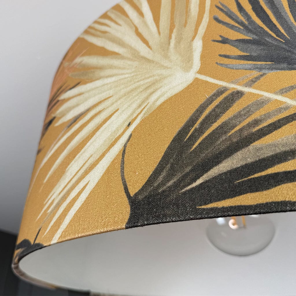 Close-up of a lampshade with tropical leaf pattern on a white background