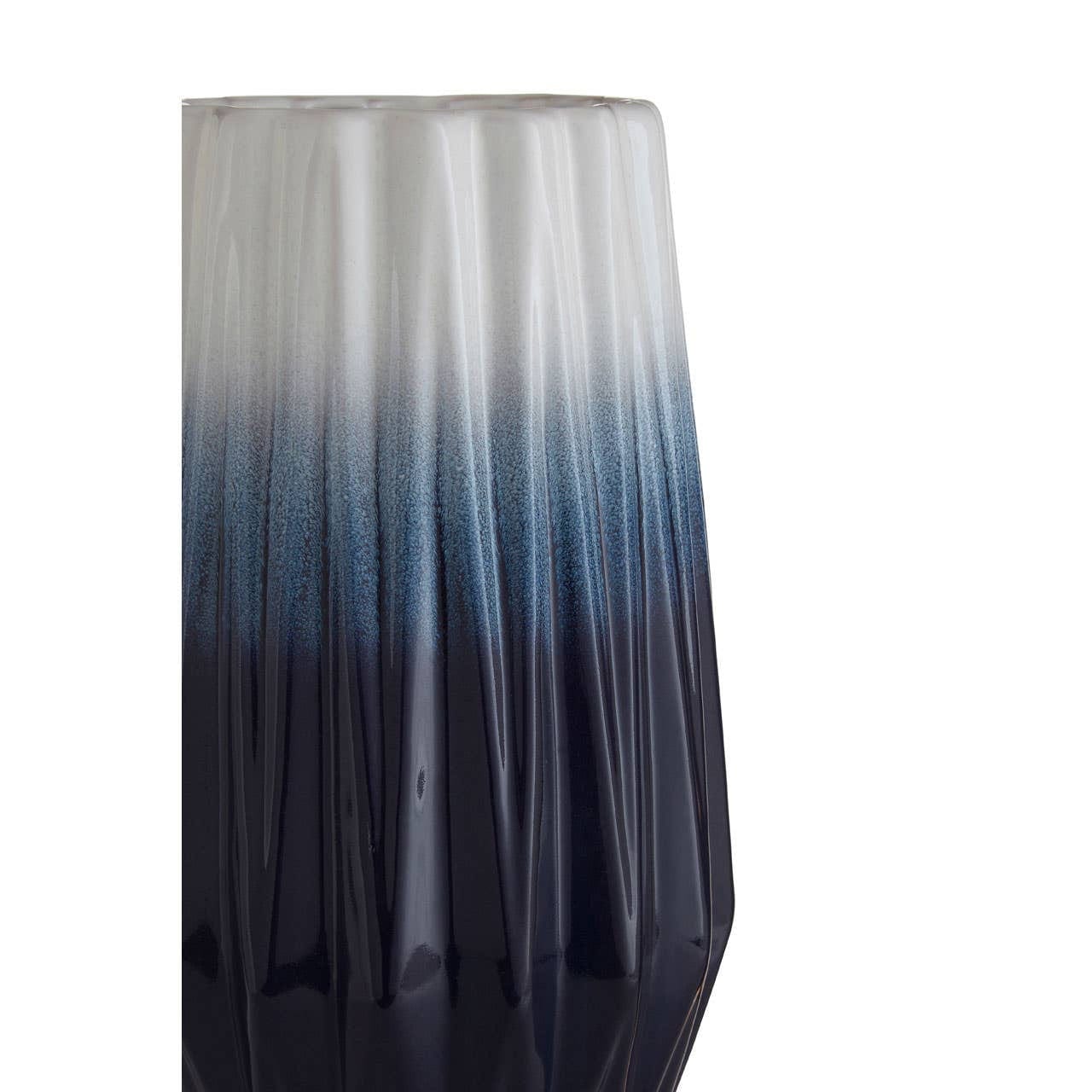 Gradient glass vase transitioning from white to blue on a white background