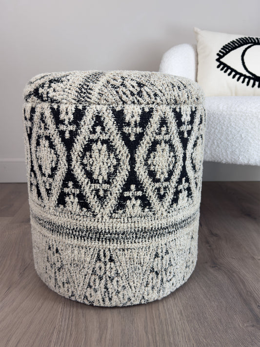 Patterned ottoman on a wooden floor with a neutral background