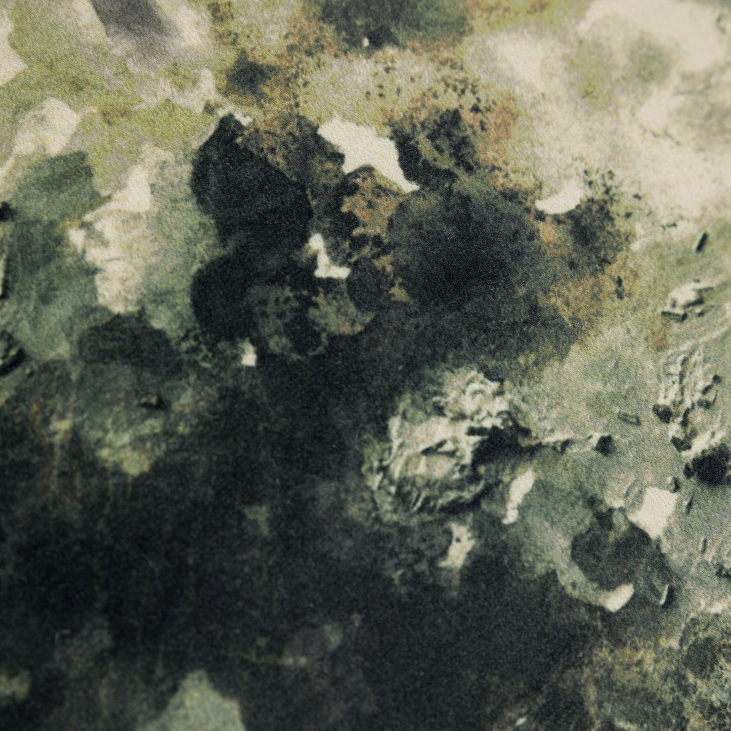 Close-up of a textured green velvet cushion surface with black and white patterns