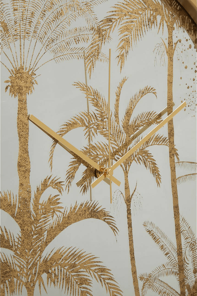 Gold clock with palm tree design on a light background
