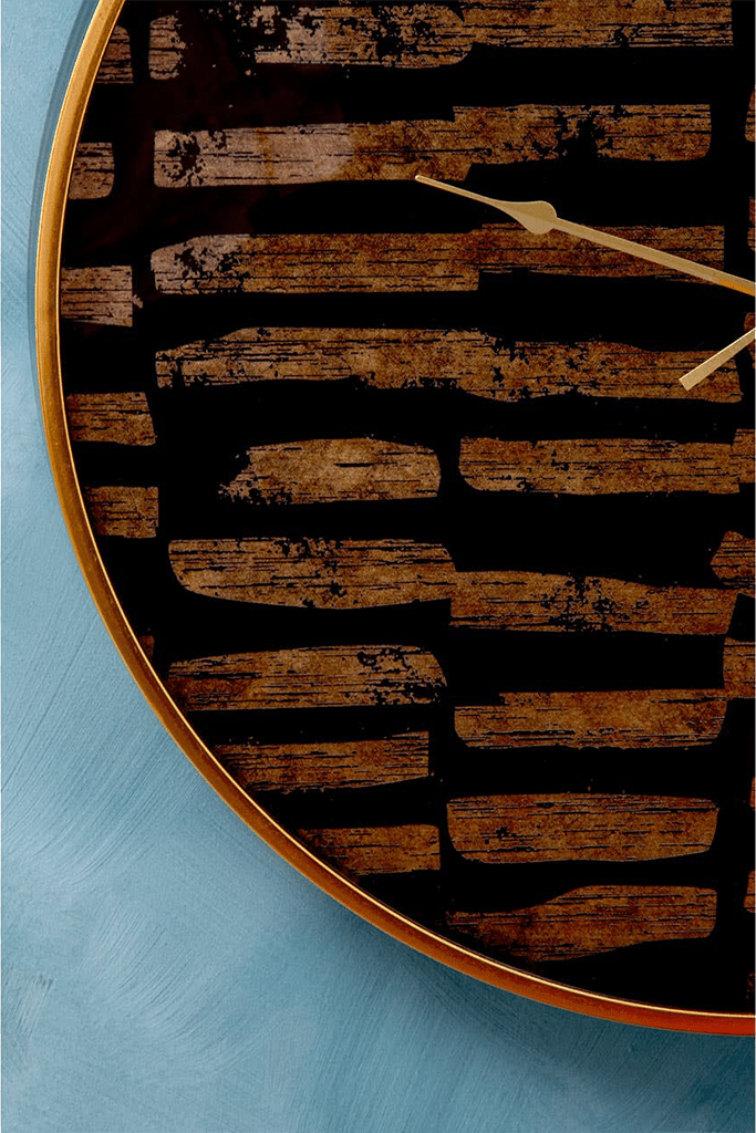 black and gold clock with a rustic design on a blue background