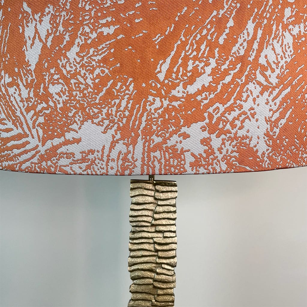 An extreme close up of the shade material and a little of the top of the gold lamp