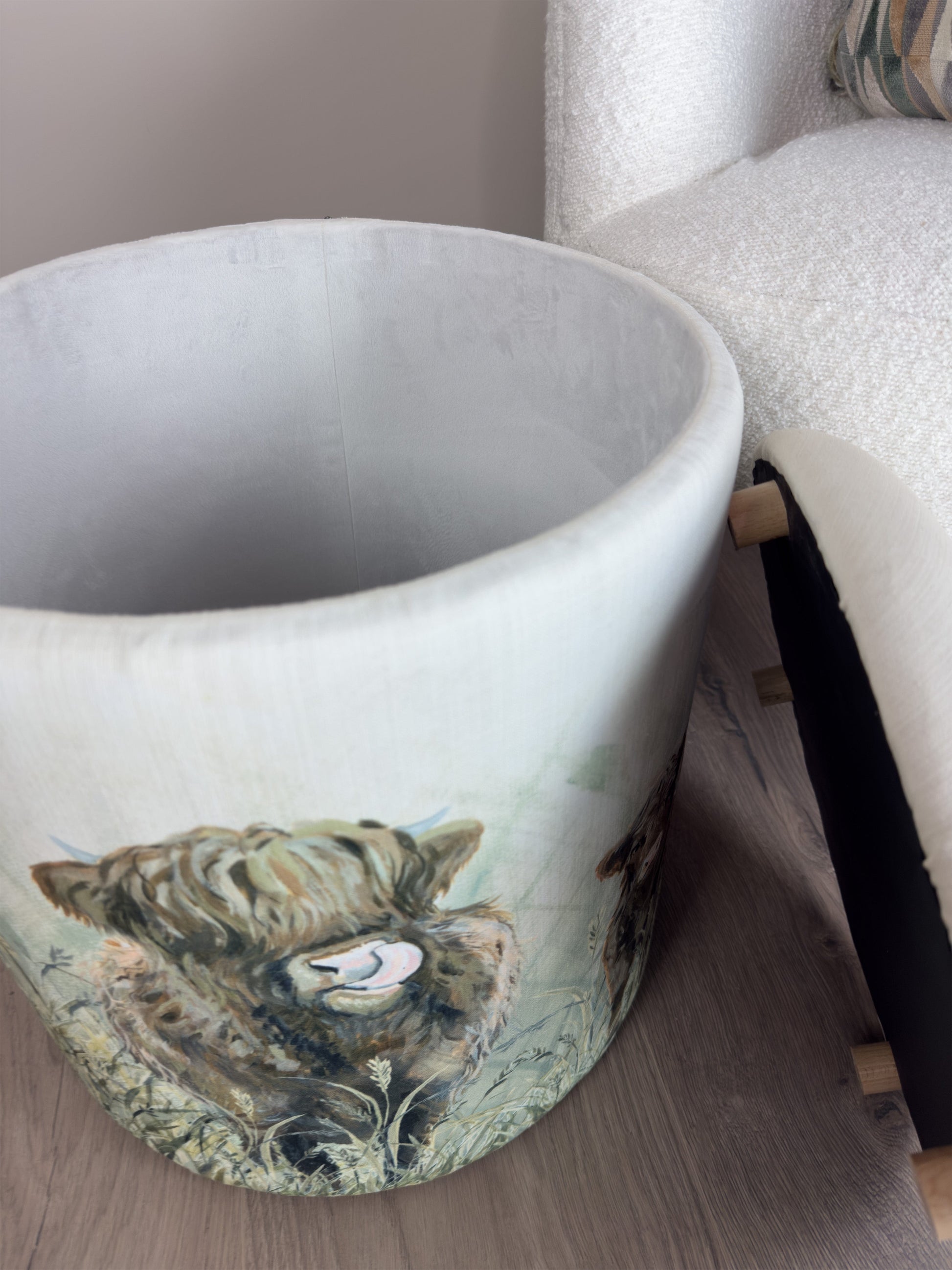 White linen storage stool, open, beside a white boucle sofa