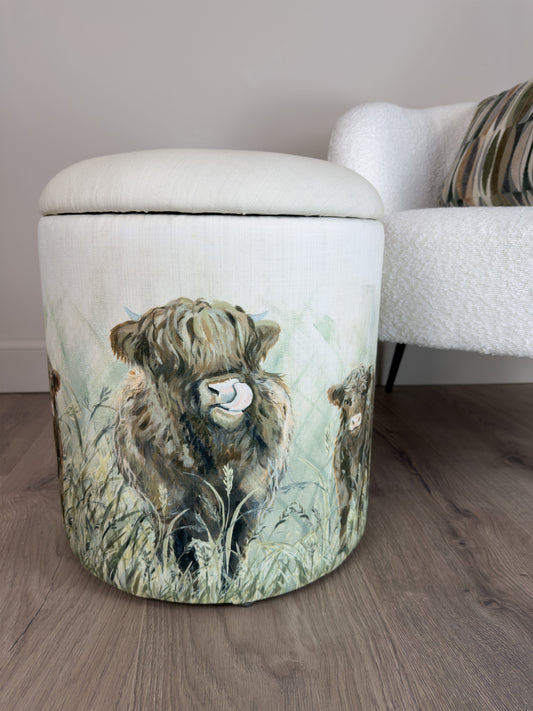 Linen Stool with a cow design on a wooden floor next to a white sofa.