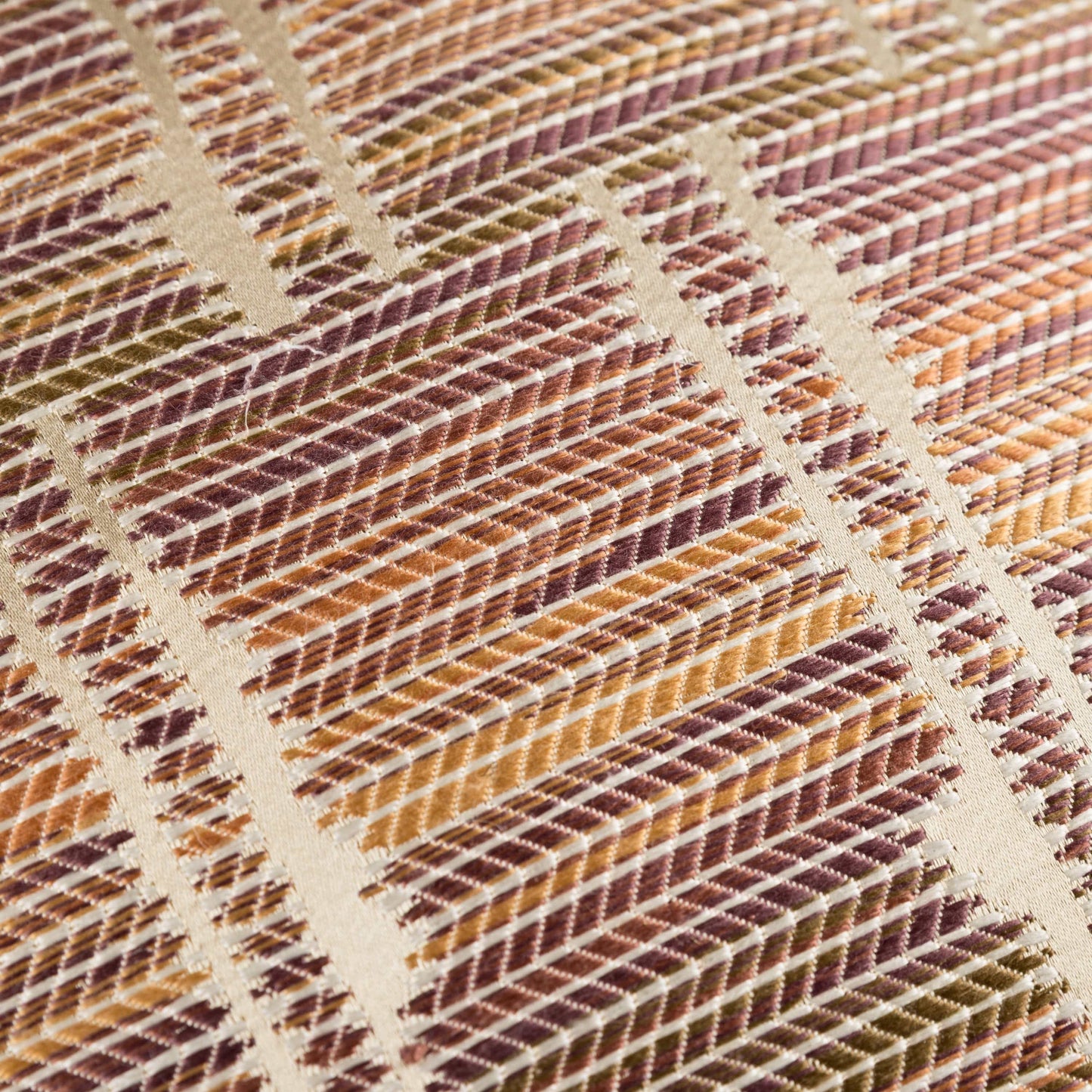 Close-up of a textured fabric with a diamond pattern in earthy tones.