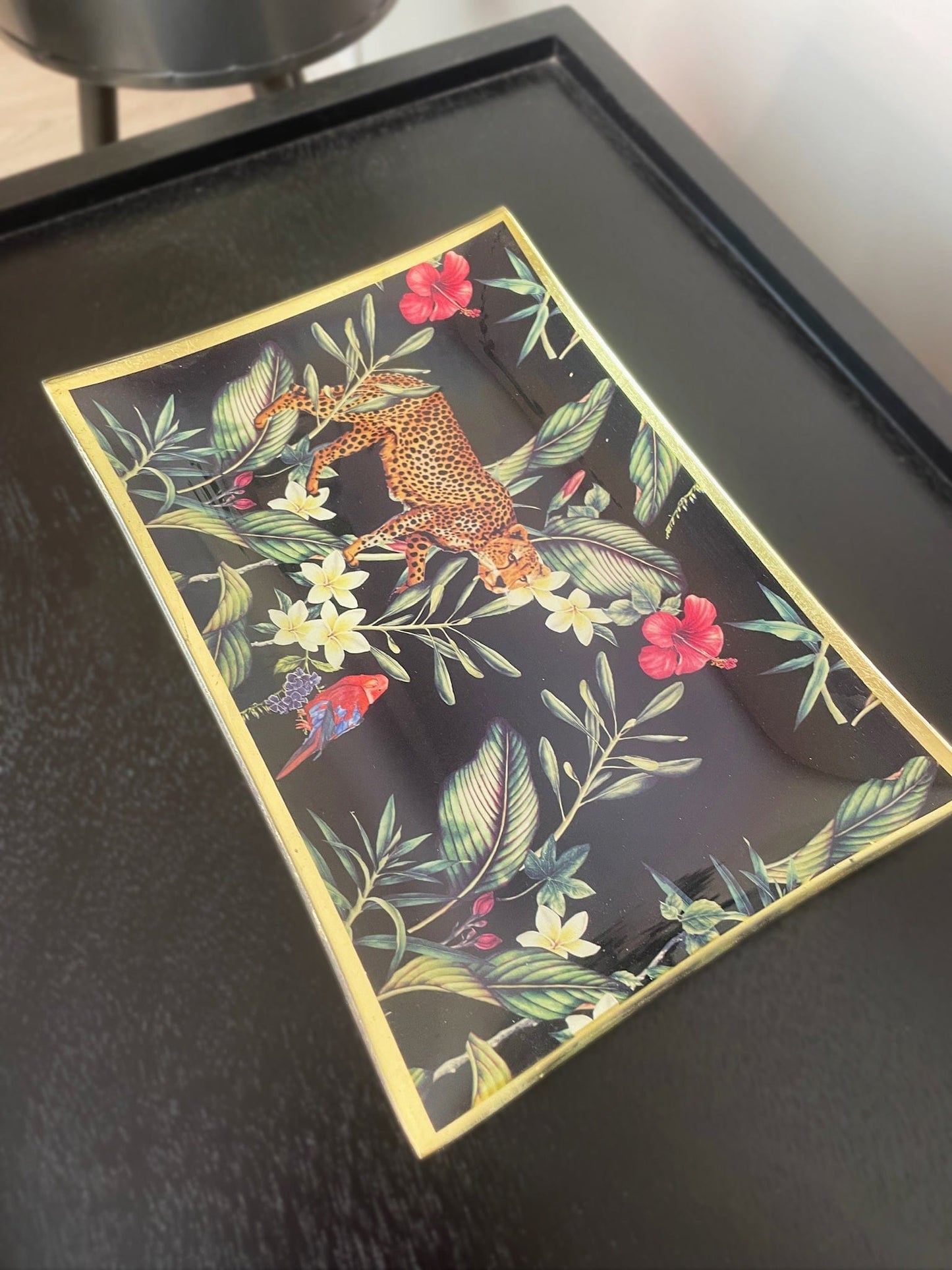 Decorative tray with a leopard and floral design on a black background