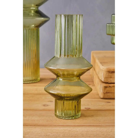 A small cylindrical green glass vase with a ribbed design, displayed on a wooden surface.