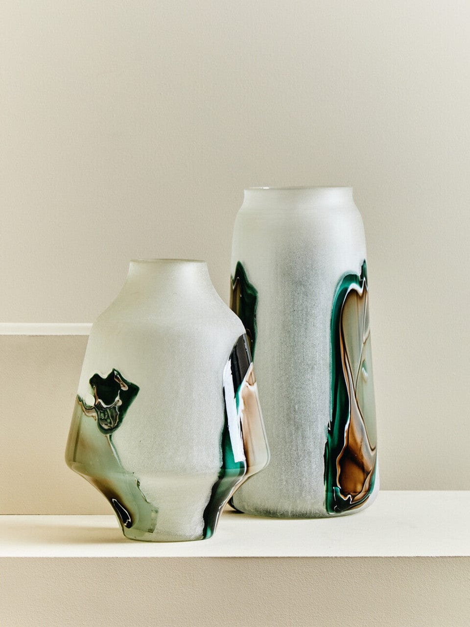 Two ceramic vases with abstract patterns on a plain background
