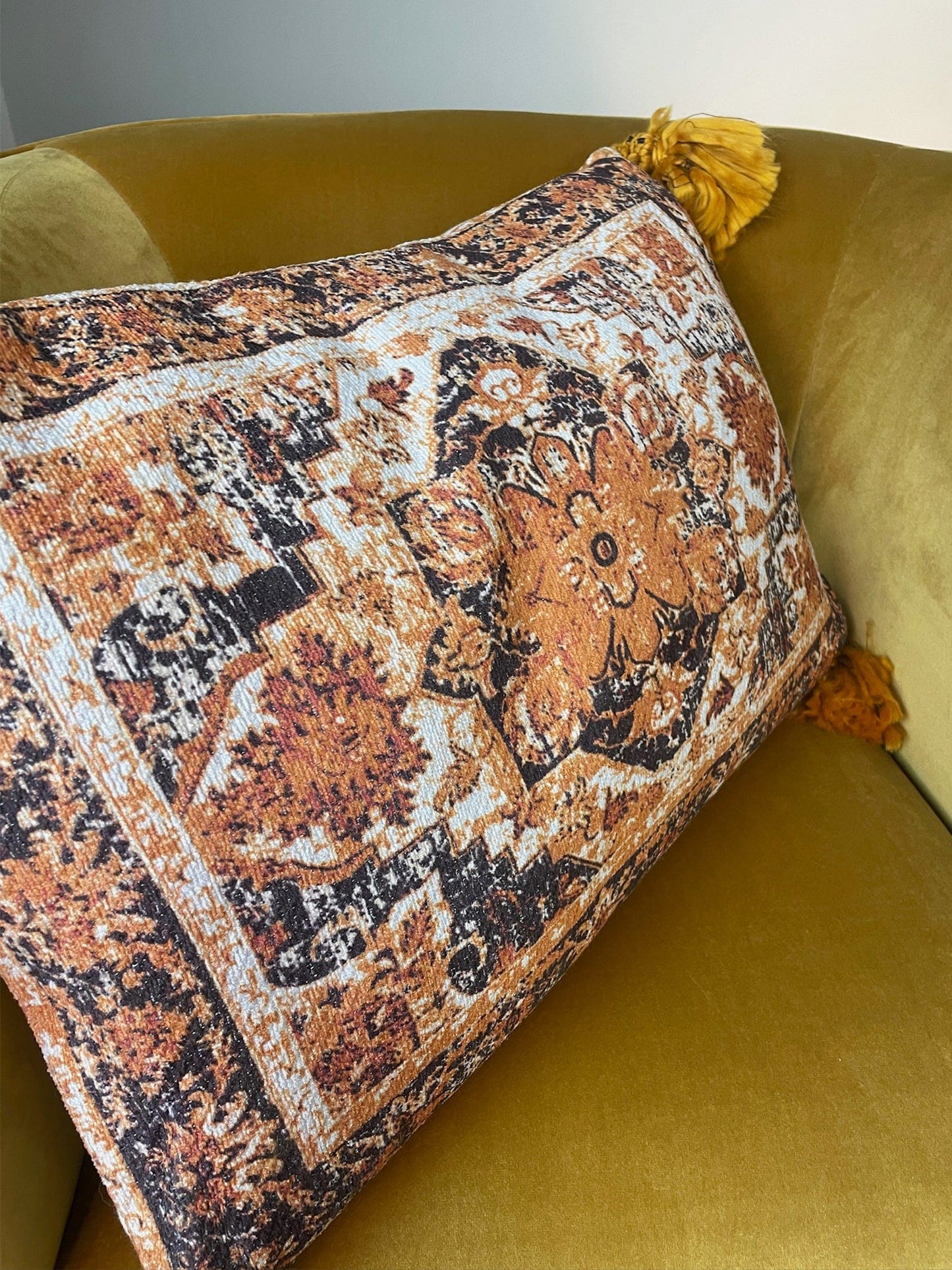 Decorative pillow with intricate patterns on a yellow sofa