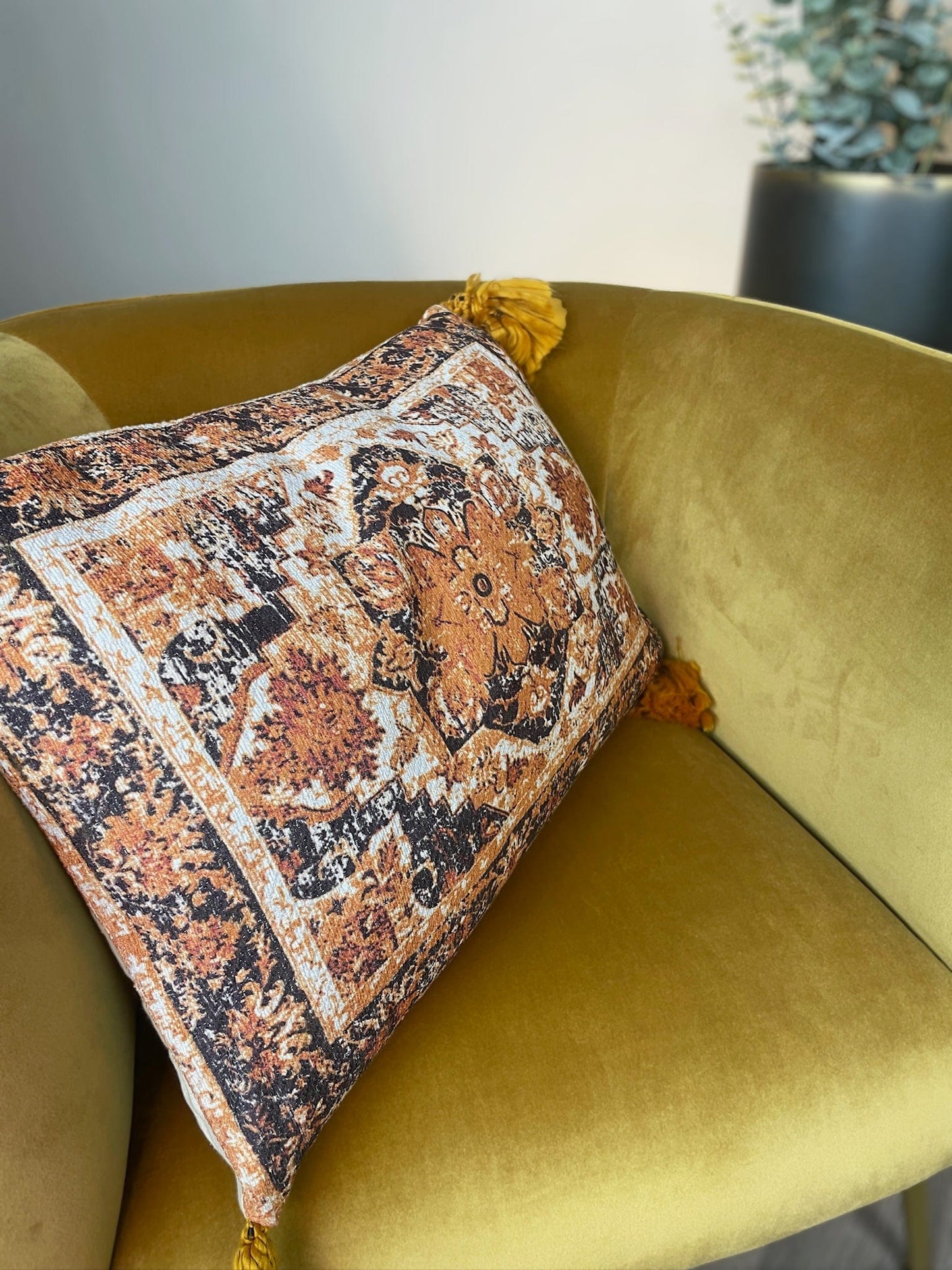 Decorative pillow with floral pattern on a mustard yellow chair