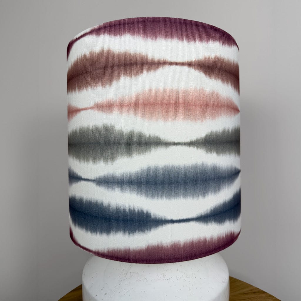 Decorative lamp with a patterned shade on a plain background