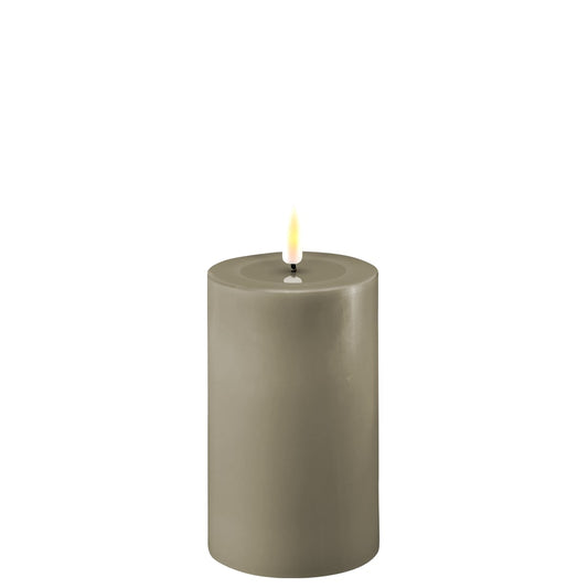 A sand-colored LED candle with a realistic appearance, featuring a small LED flame at the top.