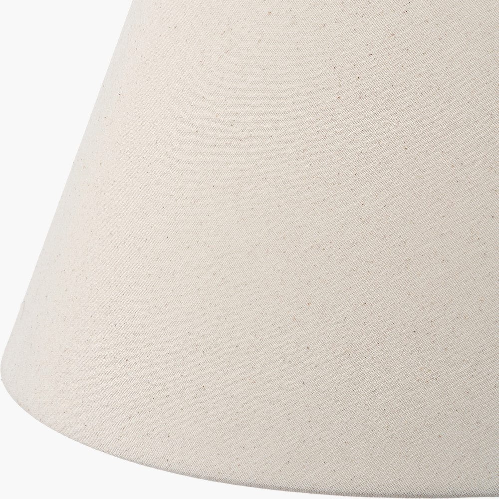Close-up of a beige lampshade with a textured surface on a white background