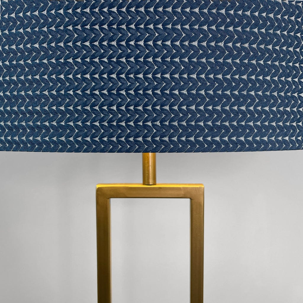 Lamp with a blue patterned shade and gold base on a gray background