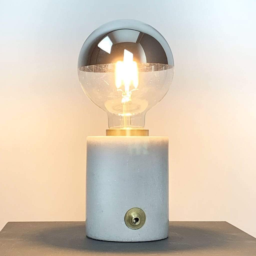 An E27 silver top 95mm globe LED light bulb with a clear glass enclosure and a metallic reflective top. In a lamp holder, lit