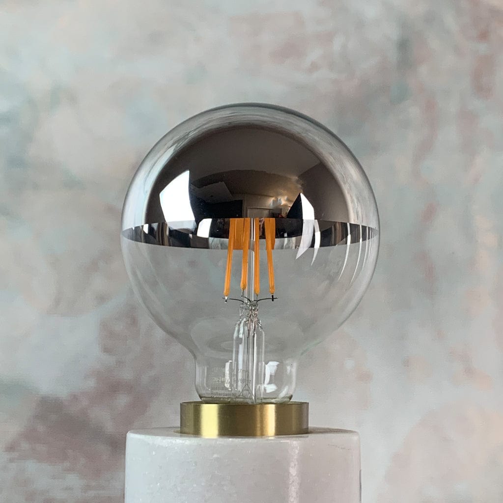 An E27 silver top 95mm globe LED light bulb with a clear glass enclosure and a metallic reflective top, in a lamp holder