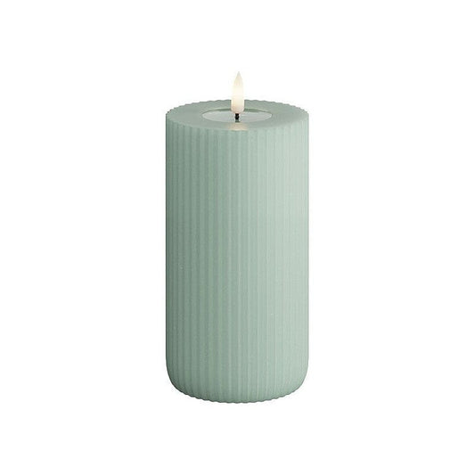 A green cylindrical LED candle with a striped pattern and a lit flame at the top.