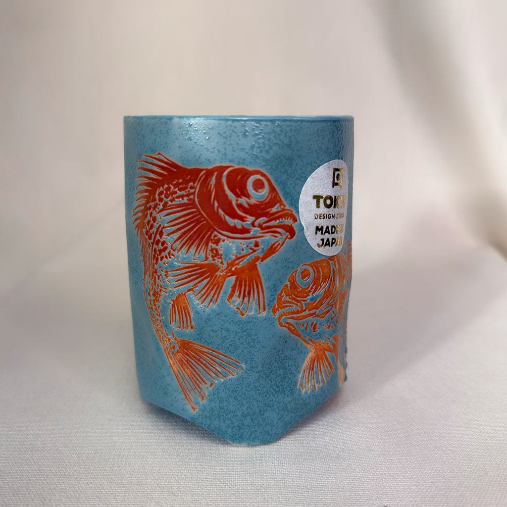 Cylindrical container with fish design and 'TOKI' branding on a light background