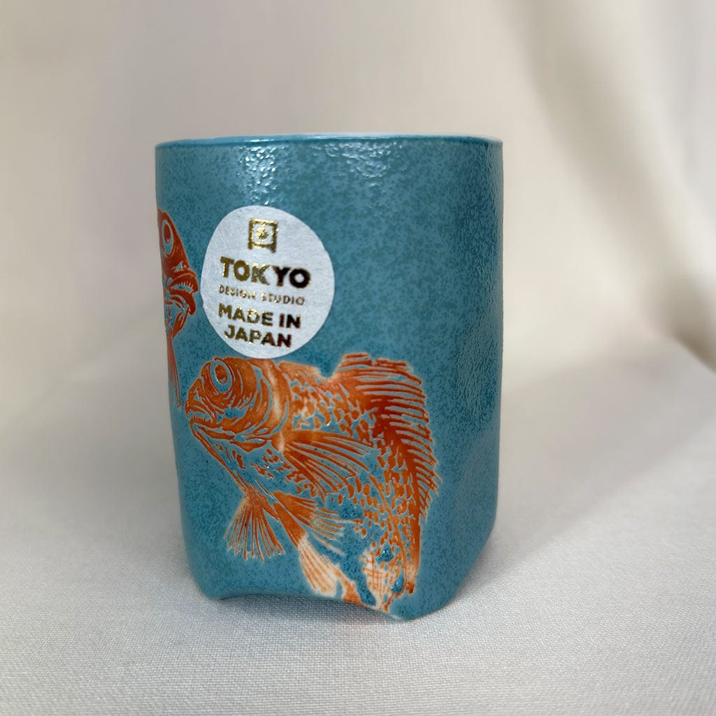 Blue cylindrical container with fish design and 'Made in Japan' label on a white background