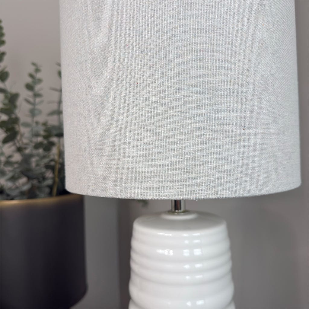 White textured lamp with a gray lampshade on a neutral background