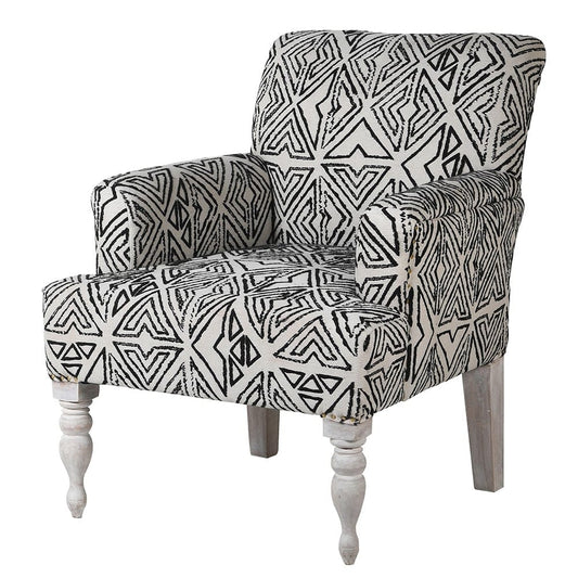 An armchair with white painted legs and a black and white geometric patterned fabric upholstery.