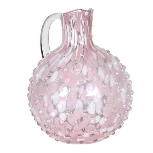 A pink glass pitcher with a confetti-style decor and a bubble effect surface.