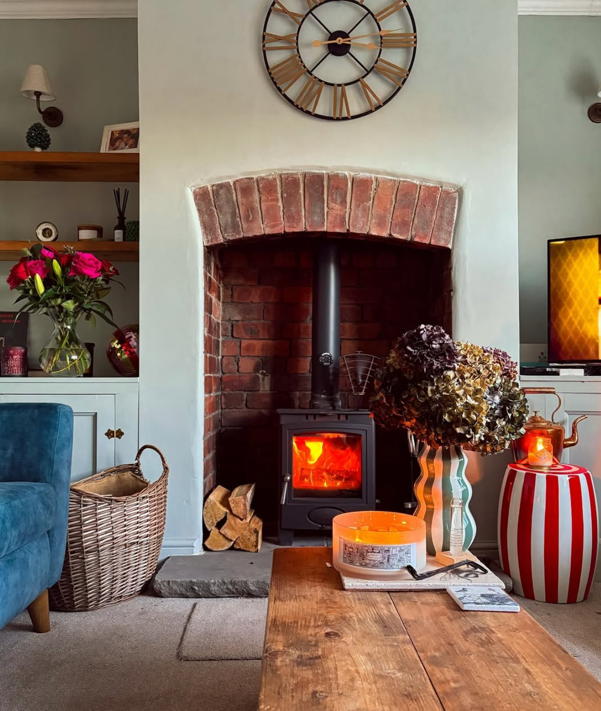 An image of a cosy fire in a green wall in a living room