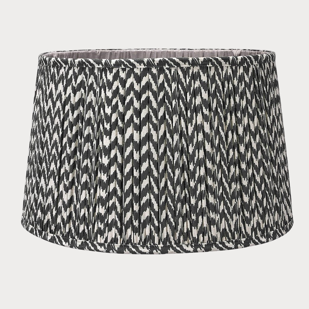 A pleated zig zag pattern lampshade in a tapered profile, predominantly in a gray color.