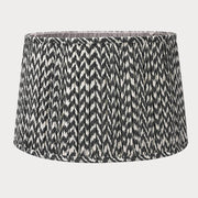 A pleated zig zag pattern lampshade in a tapered profile, predominantly in a gray color.
