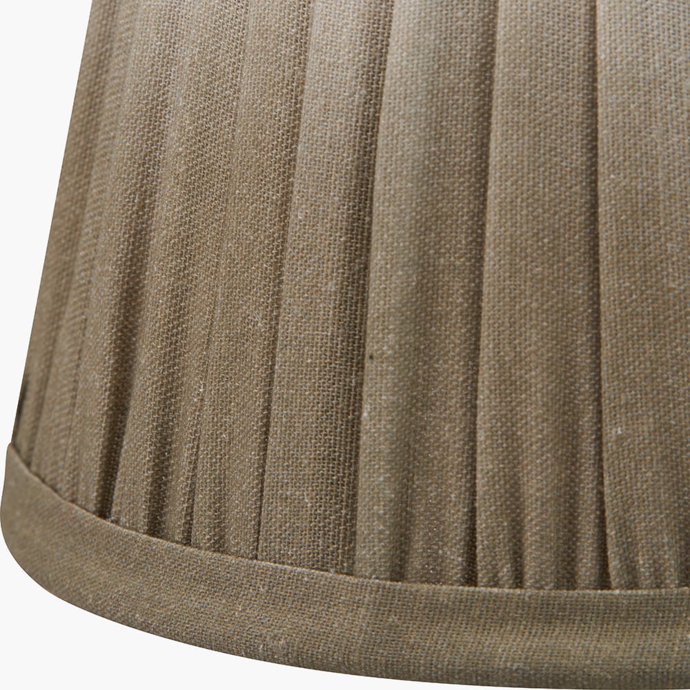 Close-up of a pleated taupe fabric lampshade on a white background