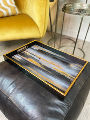Decorative tray with abstract design on a black leather ottoman