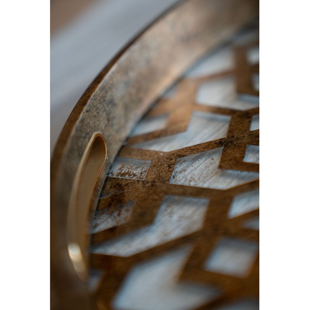 Close-up of a decorative tray with geometric patterns and a handle.