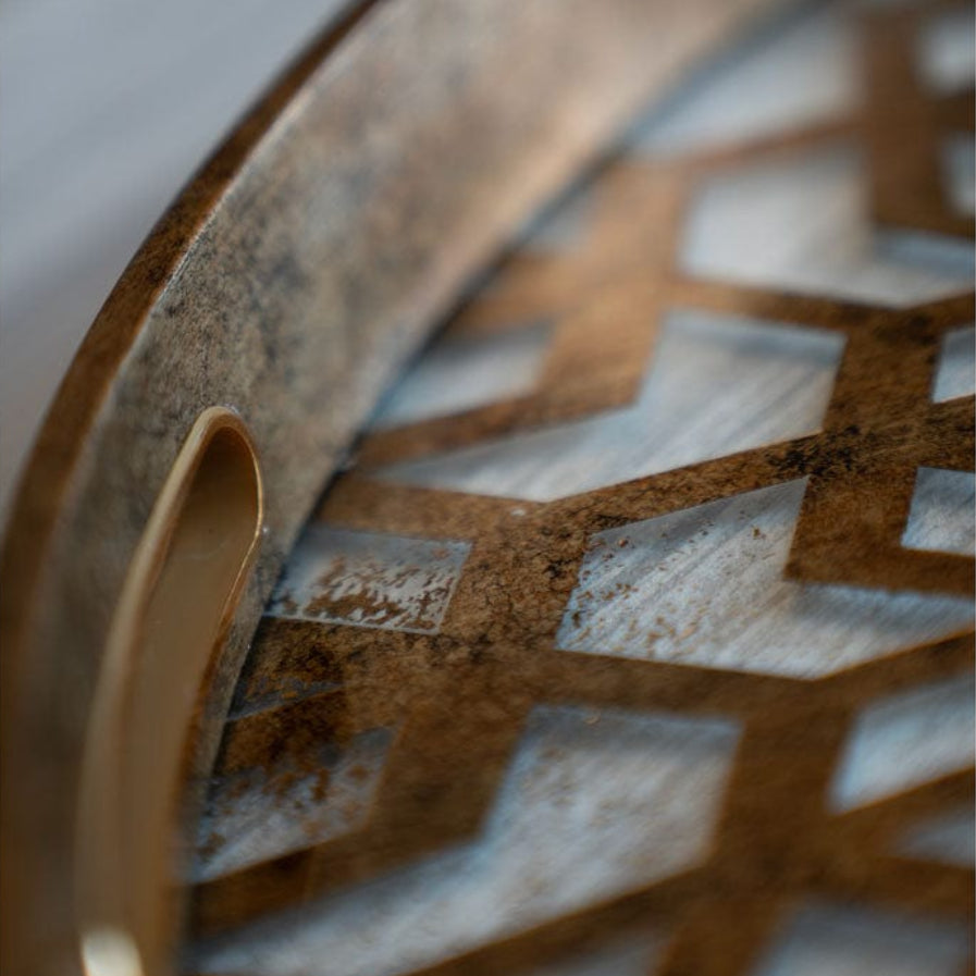 Close-up of a decorative tray with geometric patterns and a handle.
