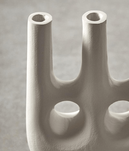 Abstract sculpture of interconnected cylindrical forms on a gray background