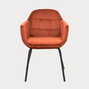 Orange velvet armchair with black legs on a white background