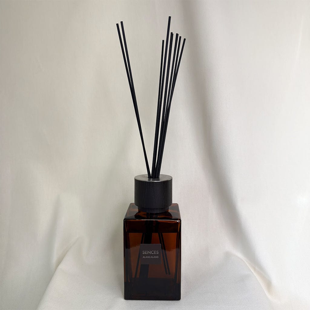 Brown diffuser bottle with black reeds on a white background