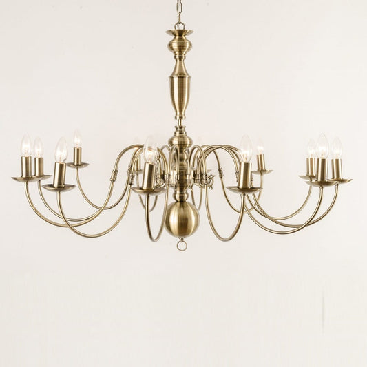 Antwerp 12 Light Antique Brass Flemish Style Chandelier with a ornate metal frame and multiple arms for candle-like lights, against a white background.