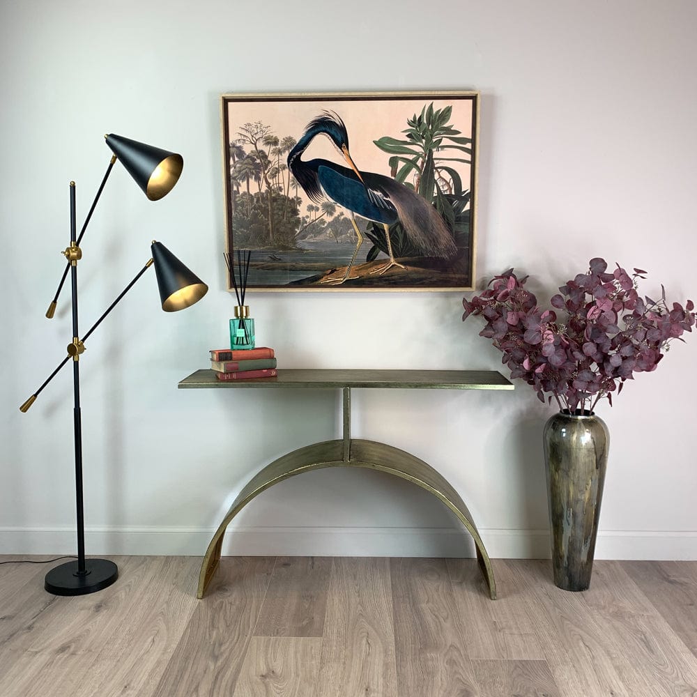 Decorative interior setting with a floor lamp, console table, and wall art.