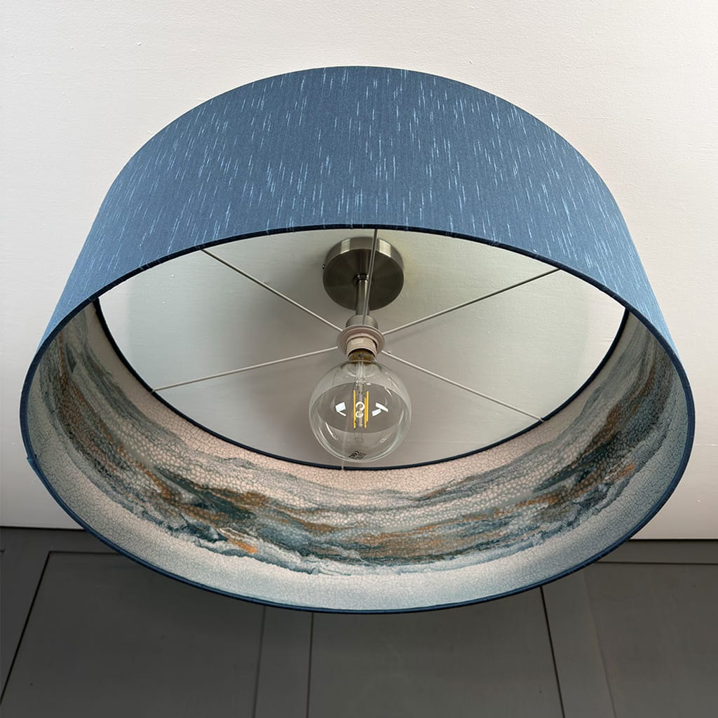 Ceiling light fixture with blue shade and visible bulb
