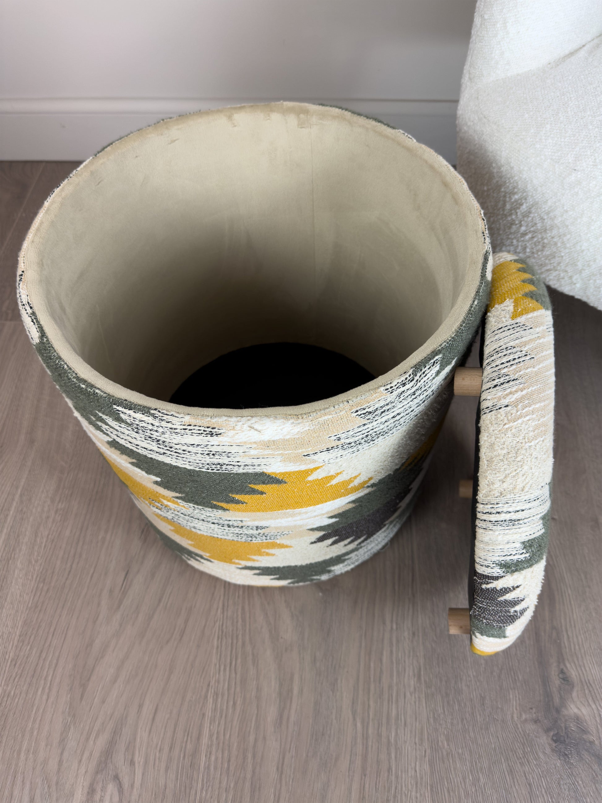 Decorative footstool with a colorful pattern on a wooden floor