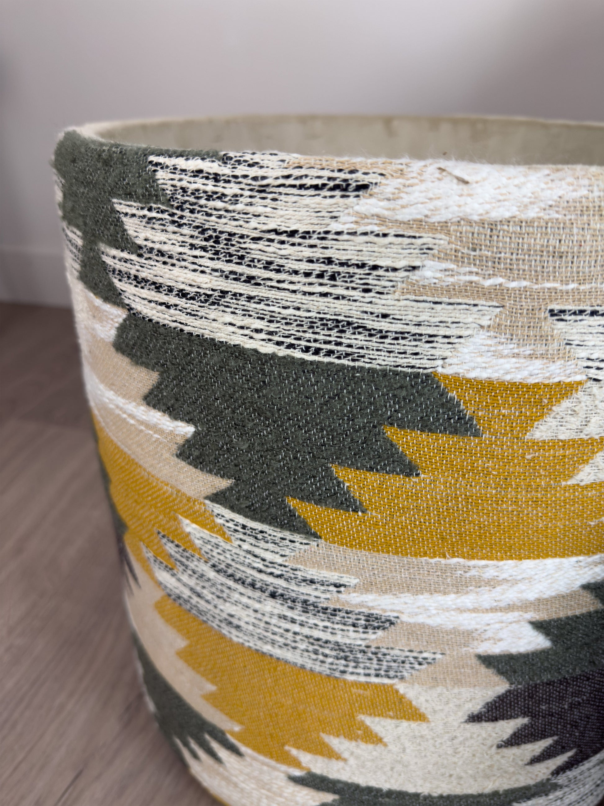 Close-up of a fabric-wrapped footstool object with geometric pattern