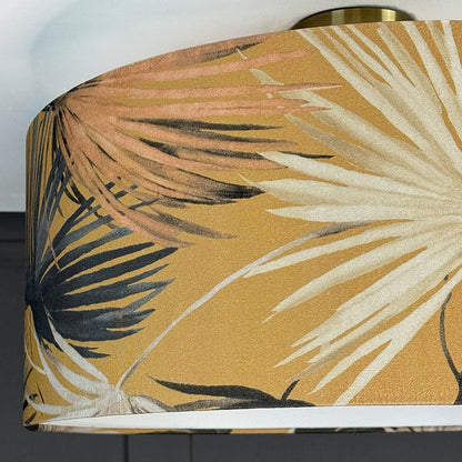 Close-up of a lampshade with tropical leaf pattern on a plain background