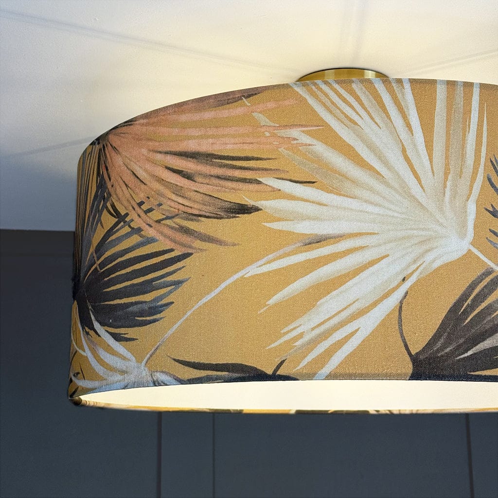 Tropical leaf patterned lampshade on a plain background