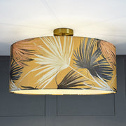 Ceiling light fixture with a tropical leaf patterned shade against a neutral background